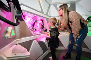 Mother and child running a science experiment in Tetrastar Spaceport lab